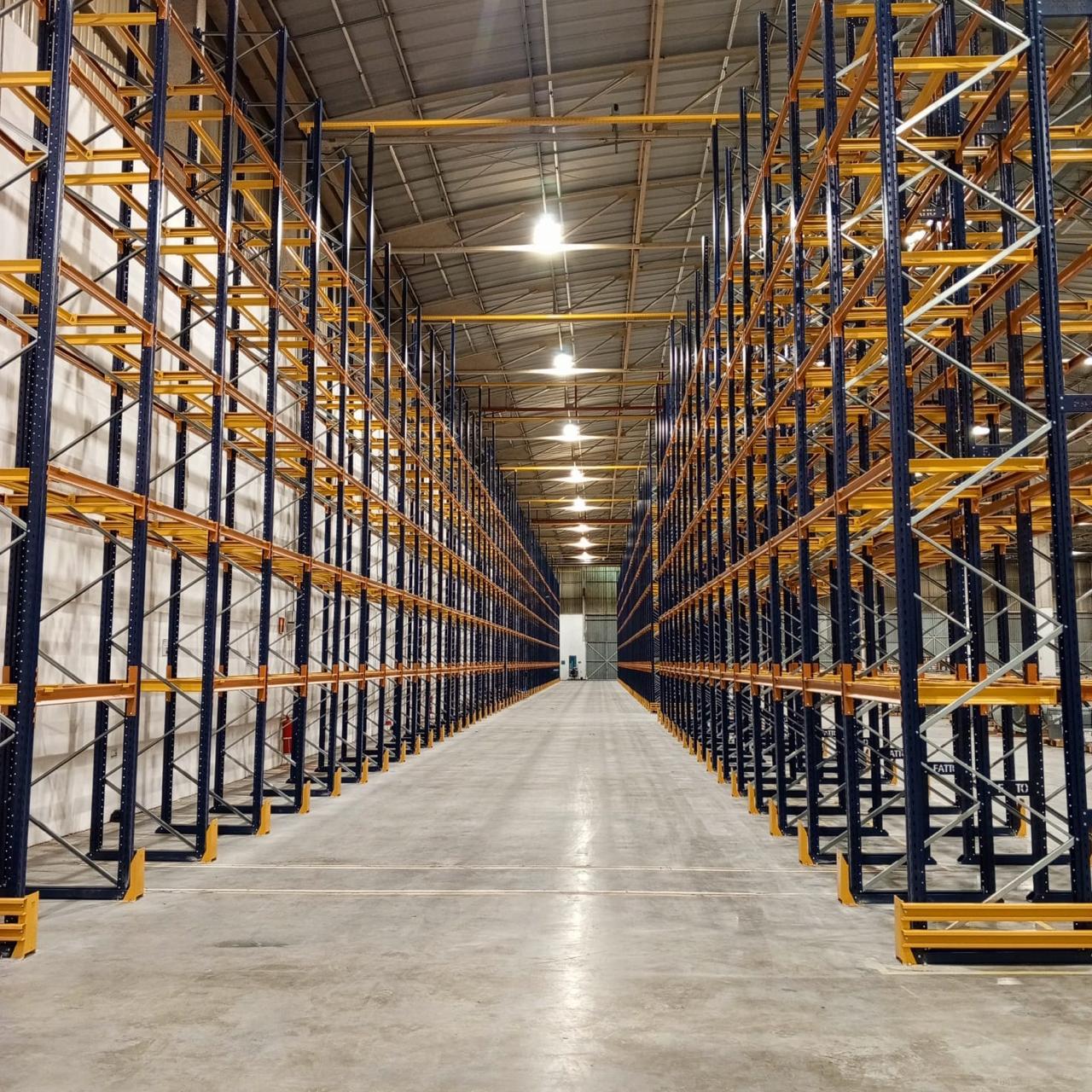 Corredor de porta paletes com empilhadeira em operação